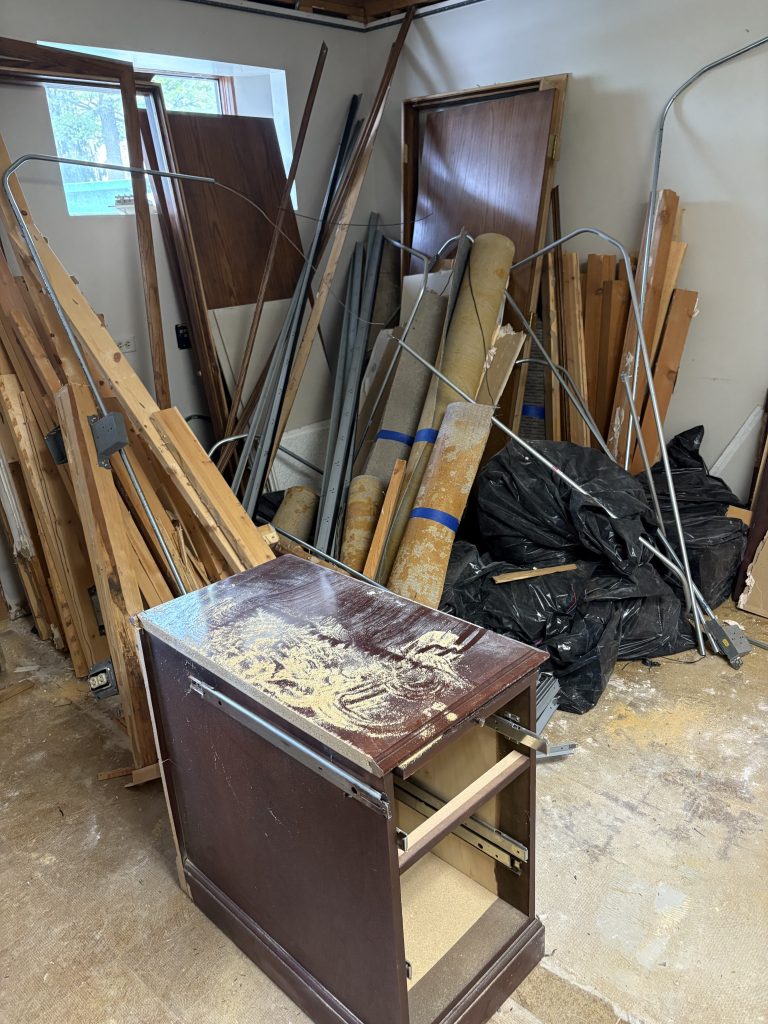 Room packed with stacked furniture, bed frames, and debris before estate furniture removal by Junk Nurse in Aurora IL