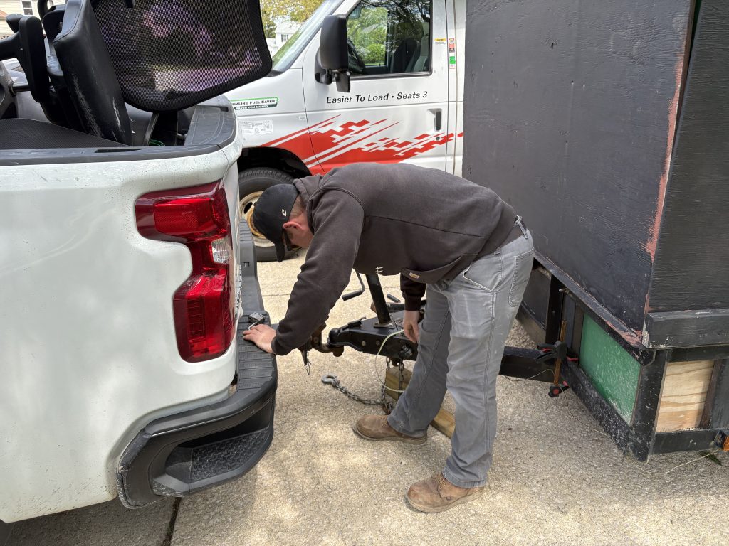 Alex Welsch connecting the trailer hitch before a junk removal job in Aurora IL