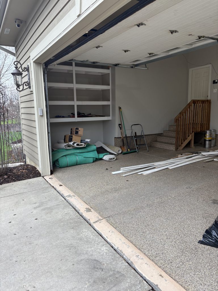 Garage cleanout in progress with bags removed and shelving cleared by Junk Nurse in Aurora IL