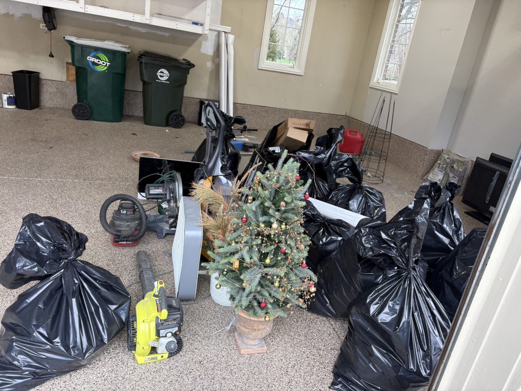Garage before cleanout showing holiday decorations, bags and old equipment removed by Junk Nurse Aurora IL