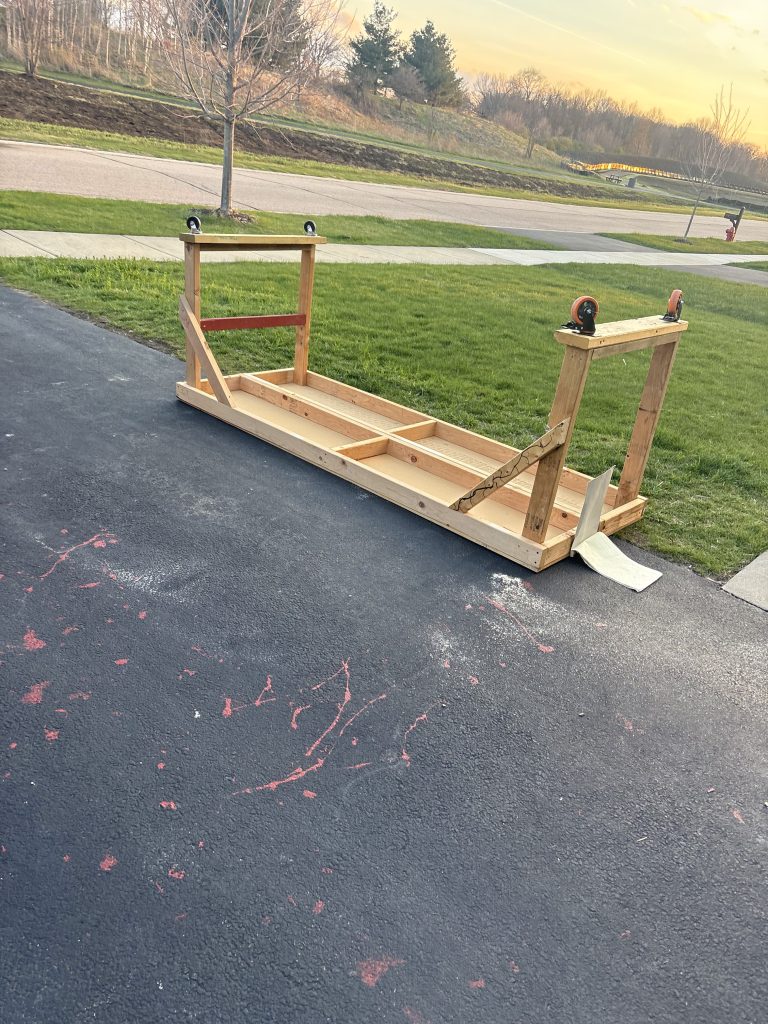 Long wooden workbench frame staged on driveway for furniture removal by Junk Nurse in Aurora IL
