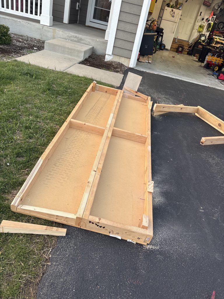 Wooden cabinet doors and furniture pieces staged on driveway for removal by Junk Nurse in Aurora IL