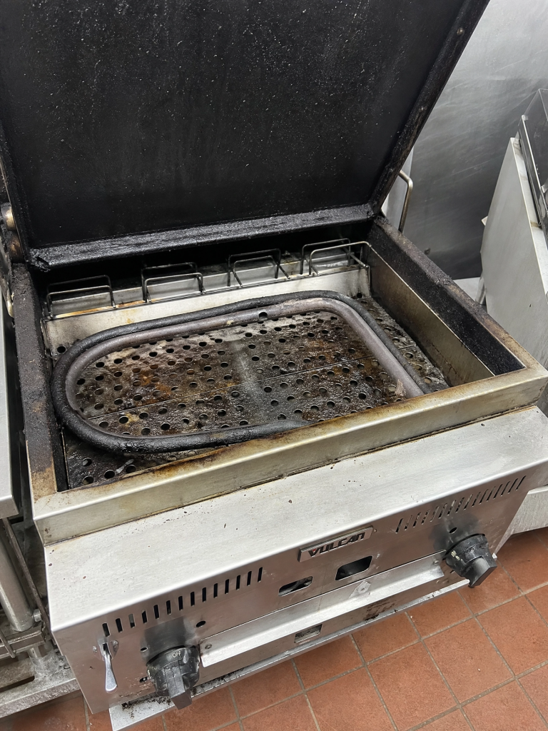 Used commercial charbroiler with open lid staged for equipment removal by Junk Nurse in Aurora IL