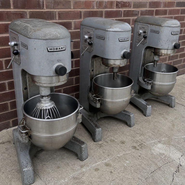 Three Hobart commercial planetary mixers lined up outside after restaurant equipment removal by Junk Nurse in Aurora IL